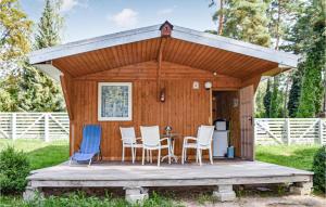 a cabin with a table and chairs on a deck at Awesome Home In Pobierowo With Kitchen in Pobierowo