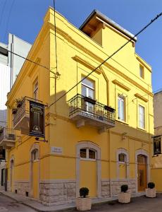 een geel gebouw met twee balkons in een straat bij Olympo in Bisceglie