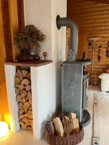 a wood fired stove with a basket of logs at 1000qm, Westerwälder Landhaustraum 