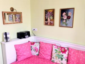 ein Zimmer mit einem rosa Sofa und rosa Kissen in der Unterkunft Hotel Schneider-Gössl in Wien
