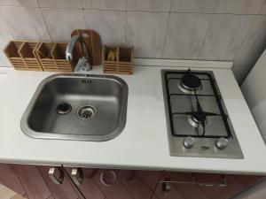 a kitchen counter with a sink and a stove at Oikos in Boscotrecase