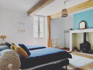 a bedroom with a blue bed and a fireplace at La Palombière in Saint-Clar