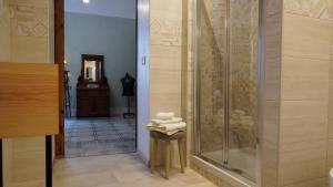 uma casa de banho com um chuveiro e uma pilha de toalhas em Baglio Sant’Angelo em Licata