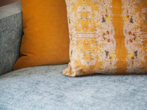 洛夫特斯的住宿－烏蘭斯萬酒店，坐在沙发上的一个橙色枕头