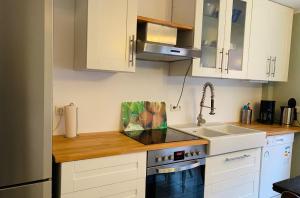 a kitchen with white cabinets and a sink at Lily-Rose Cottage in Vastorf
