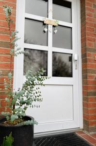 a white door with a potted plant in front of it at Lily-Rose Cottage in Vastorf