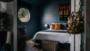 Dormitorio azul con cama y ventana en Mill House Studio, en Lyonville