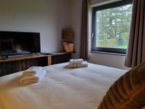ein Schlafzimmer mit einem großen Bett mit Handtüchern darauf in der Unterkunft Q-time Barvaux, Durbuy in Durbuy