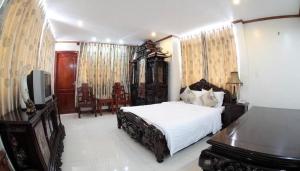 um quarto com uma cama, um piano e uma televisão em Hotel Kally Saigon em Ho Chi Minh