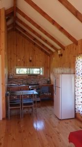 - une cuisine avec un réfrigérateur et une table dans la chambre dans l'établissement Cabañas Sotobosque, à Puelo
