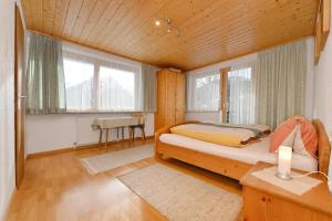 ビュルサーベルクにあるHaus Valugaのベッドルーム1室(ベッド1台、テーブル、窓付)