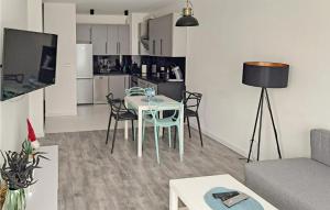 a living room with a table and chairs and a kitchen at Beautiful Apartment In Koszalin in Koszalin