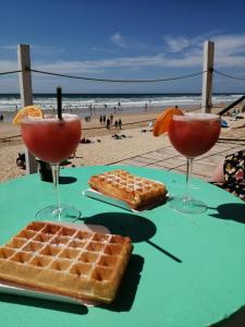 een tafel met twee wafels en twee cocktails op het strand bij Chambre d'hôte Margot'te in Mimizan