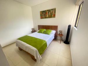 a bedroom with a bed with a green blanket on it at G308-Hermoso Apartamento en la Tebaida,en condominio campestre in La Tebaida +19 photos