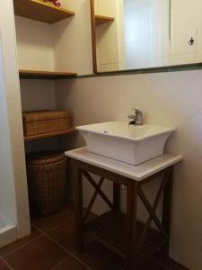een badkamer met een witte wastafel en een spiegel bij Casa La Higuera in Chulilla