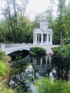 un puente sobre un estanque con un cenador blanco en Augļu ielas viesu māja en Jūrmala