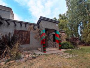a house with christmas decorations on the front of it at Casa de campo de piedra in Tunuyán