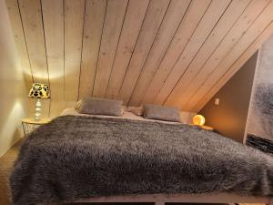 um quarto com uma cama grande e um tecto em madeira em La Cabane des salines proche mer em Mesquer