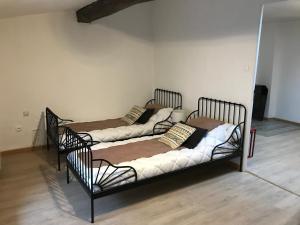 2 Einzelbetten in einem Zimmer mit in der Unterkunft Le grenier de Manée in Villemoustaussou