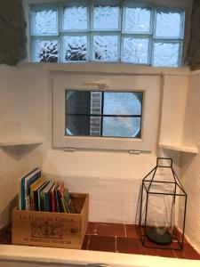 a window in a room with a box of books at Le grenier de Manée in Villemoustaussou