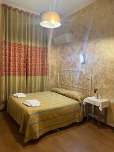 a bedroom with a bed and a table and a lamp at Roma Guest House in Rome