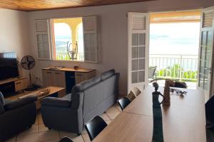 a living room with a couch and a table at Magnifique Villa Collinos avec piscine et jardin in Schœlcher