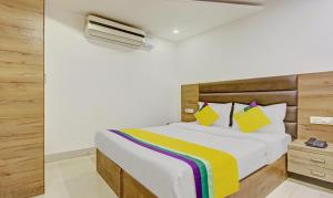 ein Schlafzimmer mit einem weißen Bett mit einer bunten Decke in der Unterkunft Itsy By Treebo - O3 in Chandīgarh