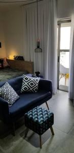 una sala de estar con un sofá azul con almohadas. en Viva Sampa!, en São Paulo