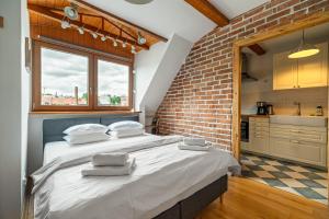 - un grand lit dans une chambre dotée d'un mur en briques dans l'établissement Blick Apartments - Riverview Studio Apartment, à Zgorzelec