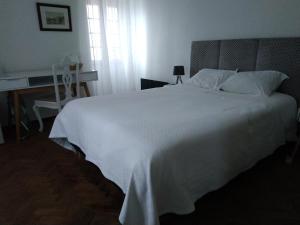 a bedroom with a large white bed with a window at AL Penaferrim Sintra Rooms in Sintra