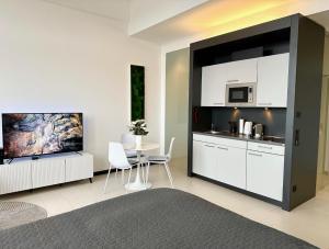 a kitchen with white cabinets and a table with chairs at MEOS 1 -Zentrum-Balkon-Parkplatz-Gym in Leipzig