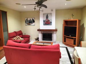 sala de estar con sofás rojos y chimenea en Don Camino Premium, en Villalcázar de Sirga