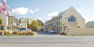 una calle en una ciudad con coches aparcados en la calle en ASURE Christchurch Classic Motel & Apartments, en Christchurch