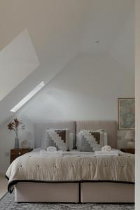 ein weißes Schlafzimmer mit einem großen Bett mit weißen Wänden in der Unterkunft Luxury Eton Cottage-Design Led in Eton