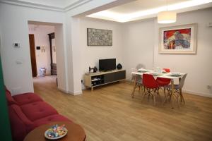 un soggiorno con divano rosso e tavolo di Uzeda Inn Apartment a Catania