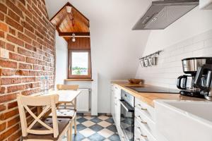 a kitchen with a table and a brick wall at Blick Apartments - Riverview Studio Apartment in Zgorzelec