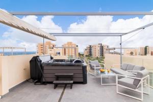 a balcony with a bath tub on top of a building at Modern villa with pool jacuzzi and sea view in La Horadada