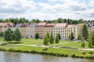 a large building next to a body of water at Blick Apartments - Riverview Studio Apartment in Zgorzelec