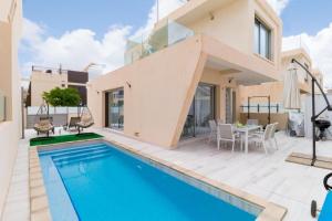 a villa with a swimming pool and a house at Modern villa with pool jacuzzi and sea view in La Horadada