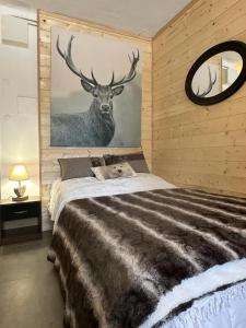 una camera da letto con un grande letto e un dipinto di cervo sul muro di font romeu a Font-Romeu-Odeillo-Via