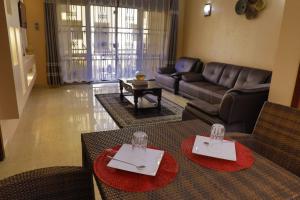 a living room with two tables and a couch at Karay Apartments in Wakiso