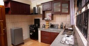 a small kitchen with a sink and a microwave at Karay Apartments in Wakiso