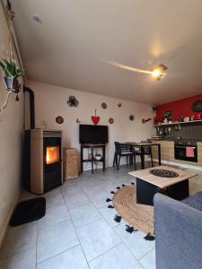 ein Wohnzimmer mit einem Kamin und einem Tisch in der Unterkunft Le Cocon - Gite Spa et Sauna privatif en Centre Alsace in Saint-Maurice