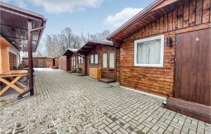 een stenen binnenplaats voor een houten gebouw bij Cozy Home In Witnica Chojenska With Kitchen 