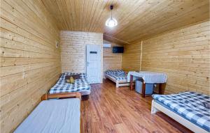 een kamer met 2 bedden in een houten hut bij Cozy Home In Witnica Chojenska With Kitchen 