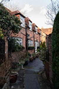 a row of brick houses with potted plants at Luxury Eton Cottage-Design Led in Eton