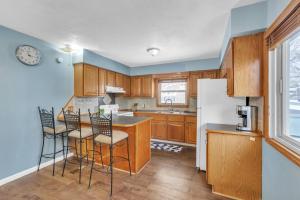 - une cuisine avec des placards en bois et un réfrigérateur blanc dans l'établissement Lovely PET FRIENDLY three bedroom in desirable Urbandale Location! home, à Wyoming