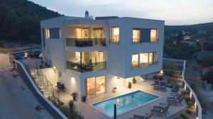 - une vue aérienne sur une maison avec une piscine dans l'établissement Villa Kapetanova Lanterna luxury apartment Barka with heated pool, à Vinišće