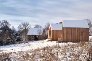un granero de madera en un campo con nieve en el suelo en Nad Poziomem, 