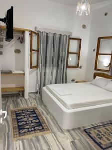 1 dormitorio con 1 cama blanca grande en una habitación en George's Home Platy Gyalos, en Kalymnos